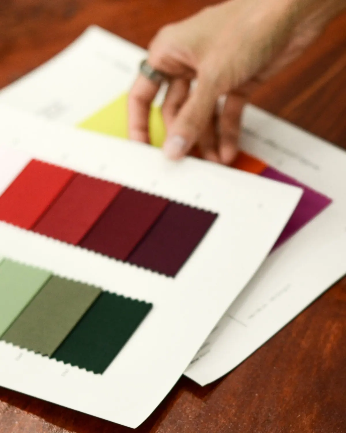 Cartelas de cores e amostras de tecido sobre a mesa de desenvolvimento.